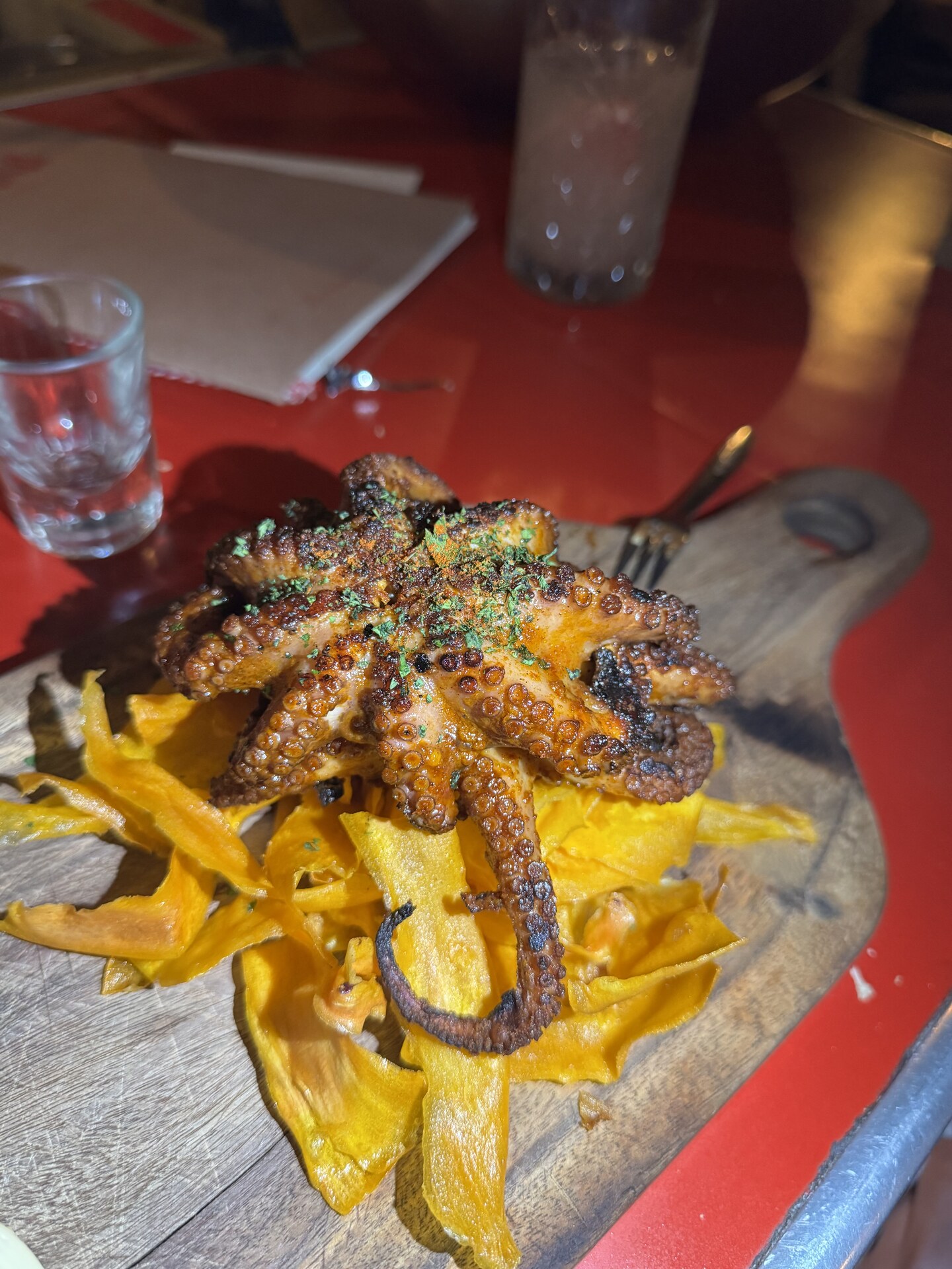Grilled octopus on plantain chips served on a wooden board at a Guadalajara restaurant